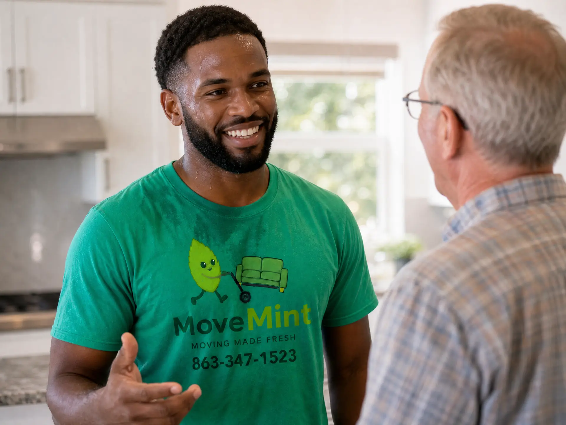 Kitchen walkthrough with the customer Friendly MoveMint crew member in a green shirt listening to an older customer during a kitchen walkthrough before a Lake County move